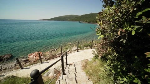 POV walk down on stone stairs leading to Adriatic Sea beach with beautiful Stock Footage 201412935