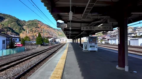 POV walking along empty train platform at Kiso Fukushima station, showcasing Stock Footage 309963472