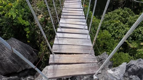 POV walking along hanging bridge between stone karst rocks on Tsingy plateau Stock Footage 312707321
