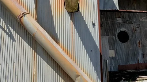 POV walking closer to a rusted old metal industrial abandoned building Stock Footage 184655659