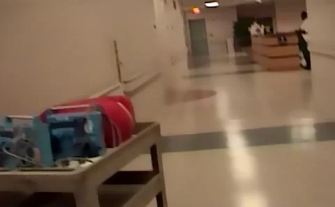 POV walking down the hallway in a hospital in 2006 wall decor and people Stock Footage 163778341