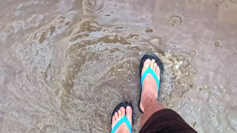 POV Walking in Flip-Flops Through Flowing Puddles on Wet Path Stock-Footage 314298351
