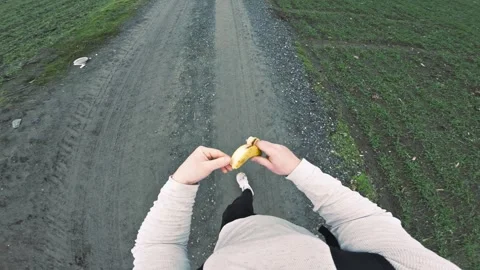 POV Walking Outdoors While Eating a Banana Stock Footage 328100218