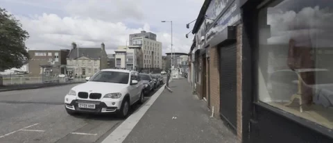 Pov of walking a sidewalk between stores and parked cars - HLG Footage Video stock 196113790
