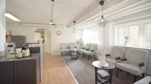 POV walking into stylish modern waiting room of clinic with receptionist behind Stock Footage 304049512