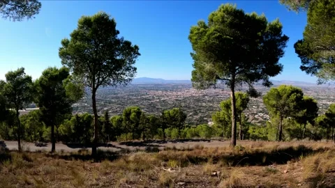 POV walking through forest at mountain top against cityscape of Murcia Vídeos de archivo 140648928