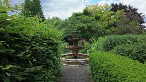 POV Walking Through Garden Path Toward Stone Fountain Video stock 336745211