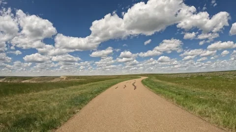 POV while driving along a narrow paved road under a summer sky with cumulus Stock Footage 337260955