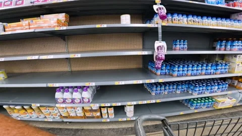 POV while pushing a cart past sparsely filled shelves of baby formula and Stock Footage 211644966