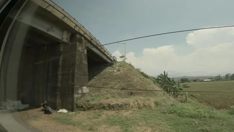 POV from window of the train that crosses under the bridge between rice fields Stockbeeldmateriaal 152982400