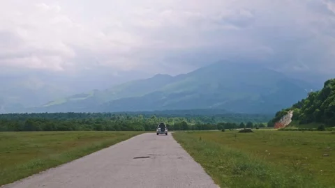 POV Windshield View of SUV Driving Towards Majestic Mountains on Country Road Stock Footage 338278023