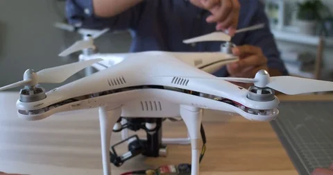 P.O.V. a woman's hands putting propellers on a drone in a tech lab Stock Footage 80314364