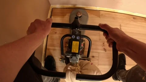 POV of a worker guiding a floor sander into a tight corner, smoothing worn Stock Footage 325843319