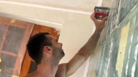 POV of young man uses brush to clean finished wall surface removing dust and sma Stock Footage 340352993