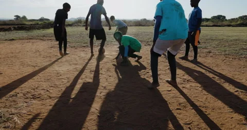 Poverty.  Slow motion. Poor Black African children playing soccer in a township Stock Footage 242500664