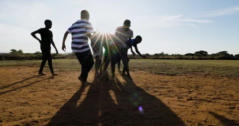 Poverty. Slow motion. Poor Black African children playing soccer in a township Video stock 242501636