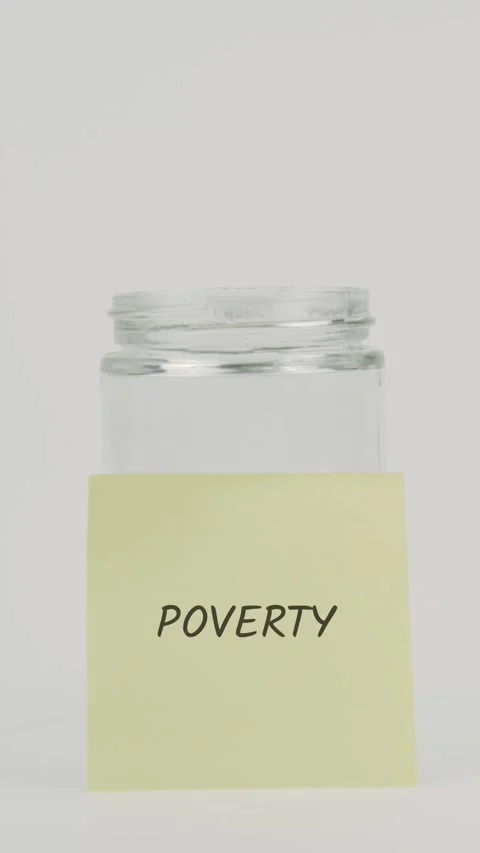 Poverty text or word on yellow sticky note attached to glass jar with hand Stock Footage 311769738