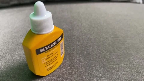 Povidon-Iodine solution yellow bottle Betadine brand antiseptic panning shot Stock Footage 247619452