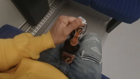 POW of man opening beer in a train Stock Footage 126628260