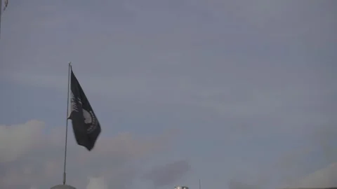 POW MIA Flag Flying on Flagpole Against Sky Stock Footage 332327733