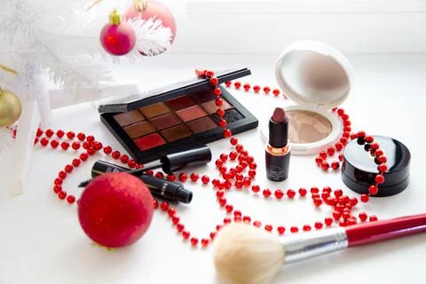 Powder and bronzer, eye shadow, lipstick, blush and a brush of different brands Stock Photos