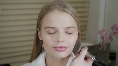 Powder base brush. Makeup artist creating beautiful makeup for blondes model Stock Footage 83562667
