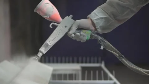 Powder coating. Man's hand with spray gun applies powder to metal object. Vídeo Stock 131739404