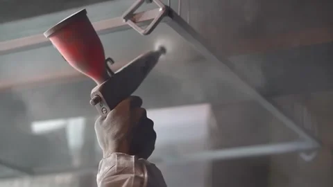 Powder coating. Man's hand with spray gun applies powder to metal object. Stock Footage 134647489