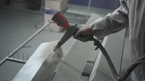 Powder coating. Man's hand with spray gun applies powder to metal object. Vídeo Stock 134730990