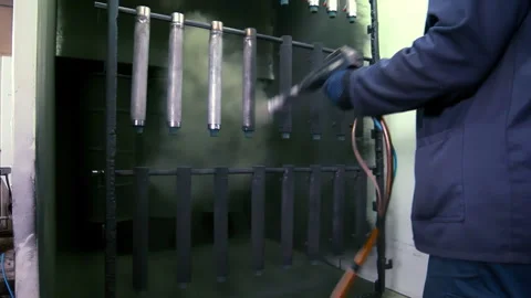 Powder coating worker spraying metal pipes paint booth. Steel finishing plant. Stock Footage 345680105
