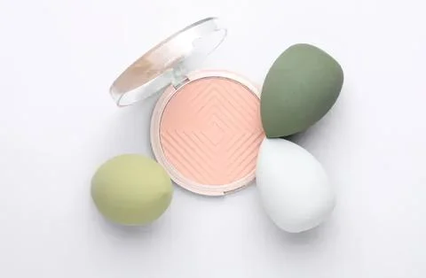 Powder compact with three colorful sponge applicators Stock Photos
