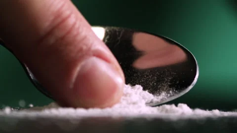 Powder moving on a spoon with a finger Stockbeeldmateriaal 172093634