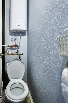 Powder room accommodates functional water meters alongside brass plumbing v.. Stock Photos