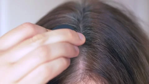 Powder sponge gently blends over gray hair roots, masking gray hairs and Stock Footage 322617858