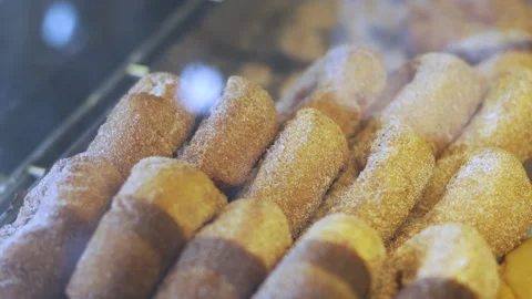 Powdered doiughnuts behind a display case Stock Footage 131238675