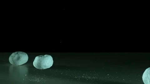 Powdered donuts falling on a dark surface Stock Footage 327052095