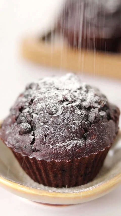 Powdered (icing) sugar falling on top of a chocolate chip muffin, close-up Stock Footage 270314553