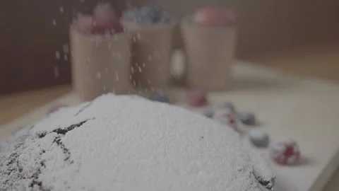 Powdered sugar dusted over a chocolate cake decorated with berries Stock Footage 346113921