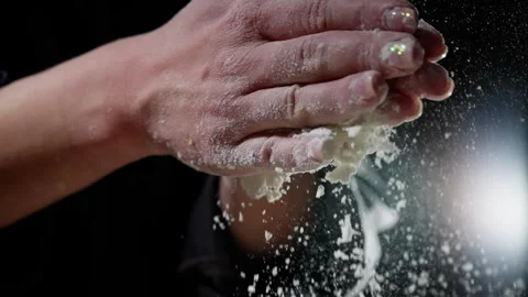 Powdery white flour falling, baker clapping hands, creating soft dust pattern Stock Footage 301647986