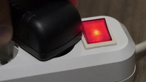 Power adapter is inserted into the electric portable socket with red indicator Stock Footage 311833111