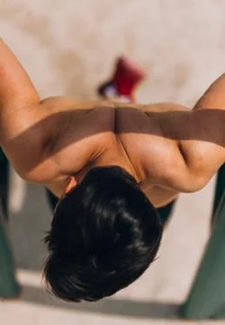 Power athletic guy execute exercise on parallel bars Foto stock