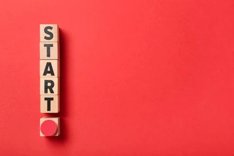 Power button and word START made of wooden cubes on red background Stock Photos