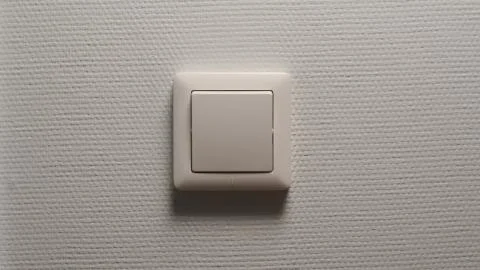 Power button on a light-grey wall - Front view 写真素材