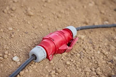 Power Cable Connector Lying on Dirt at Outdoor Work Site Stock-Fotos