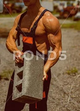 Power concept. Brick in fit arms with biceps and triceps muscle, power. Muscular Stock Photos