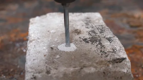 Power drill bit boring a hole into concrete block Stock Footage 327663244