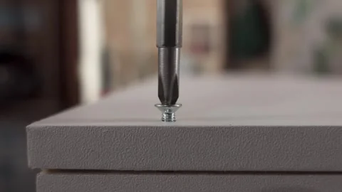 Power drill inserting a self-tapping screw into plywood surface Stock Footage 326063802