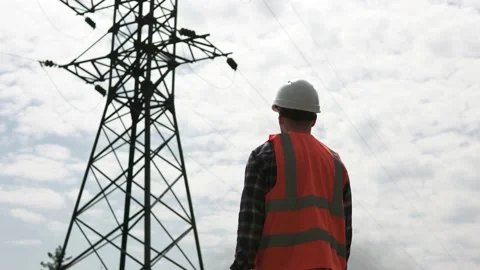 A power engineer inspects a high-voltage power line pylon. Stock Footage 239326803