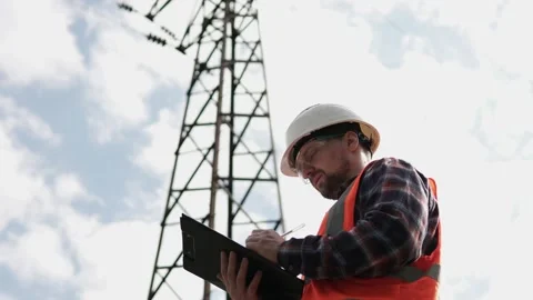 The power engineer inspects the high-voltage line and writes the data to the log Stock Footage 240720698