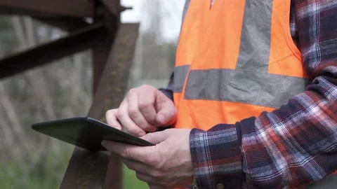 The power engineer inspects the power line and records the data on the tablet. Stock Footage 240082866